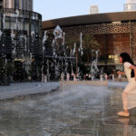 A child runs through a fountain in front of the Dubai Opera on May 24, as pre-summer temperatures soar in the UAE. (Giuseppe Cacace / AFP via Getty Images)