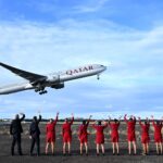 Virgin Australia cabin crew wave goodbye to the inaugural VA1 service from Sydney to Doha beside the runway at Sydney International Airport on Thursday. Virgin Australia is returning to international long-haul flights through an alliance with Qatar Airways five years after the pandemic forced it into administration and two years since Qatar Airways was initially blocked from expanding in Australia. (James D. Morgan/Getty Images for Virgin Australia)