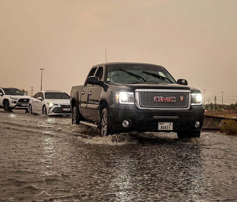 People drive their cars along a flooded road amid unseasonably heavy rainfall on the outskirts of Dubai on Monday. (Fadel Senna/AFP via Getty Images)